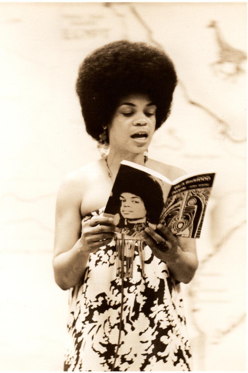 Photo of Sonia Sanchez reading form one of her books of poetry
