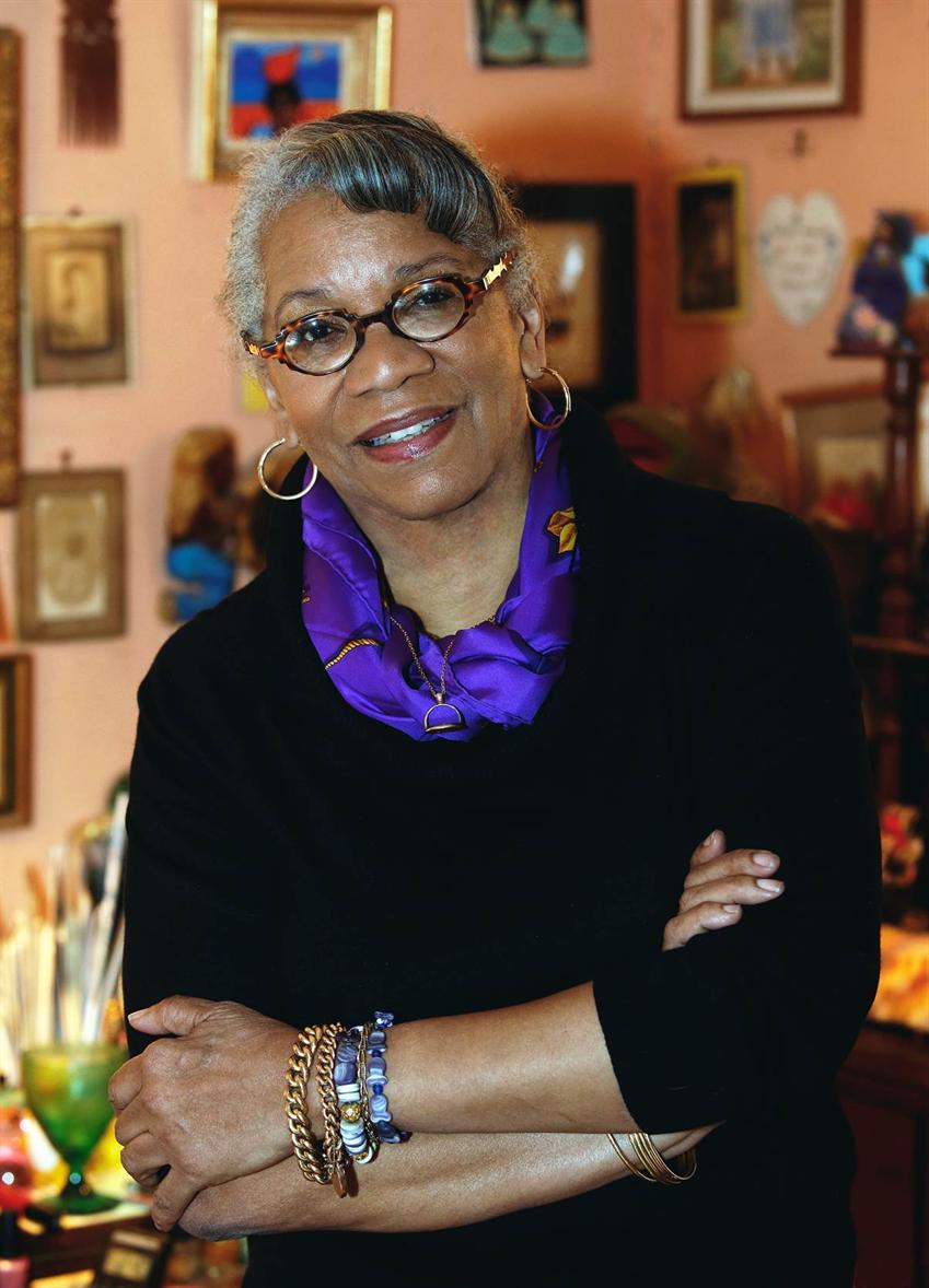 portrait photo of Jessica Harris wearing a black dress with a deep purple scarf around her neck.