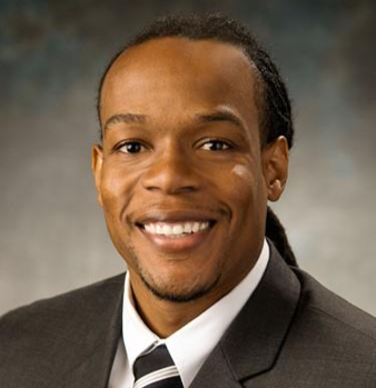 African American man smiles at camera while wearing great suit and striped tie