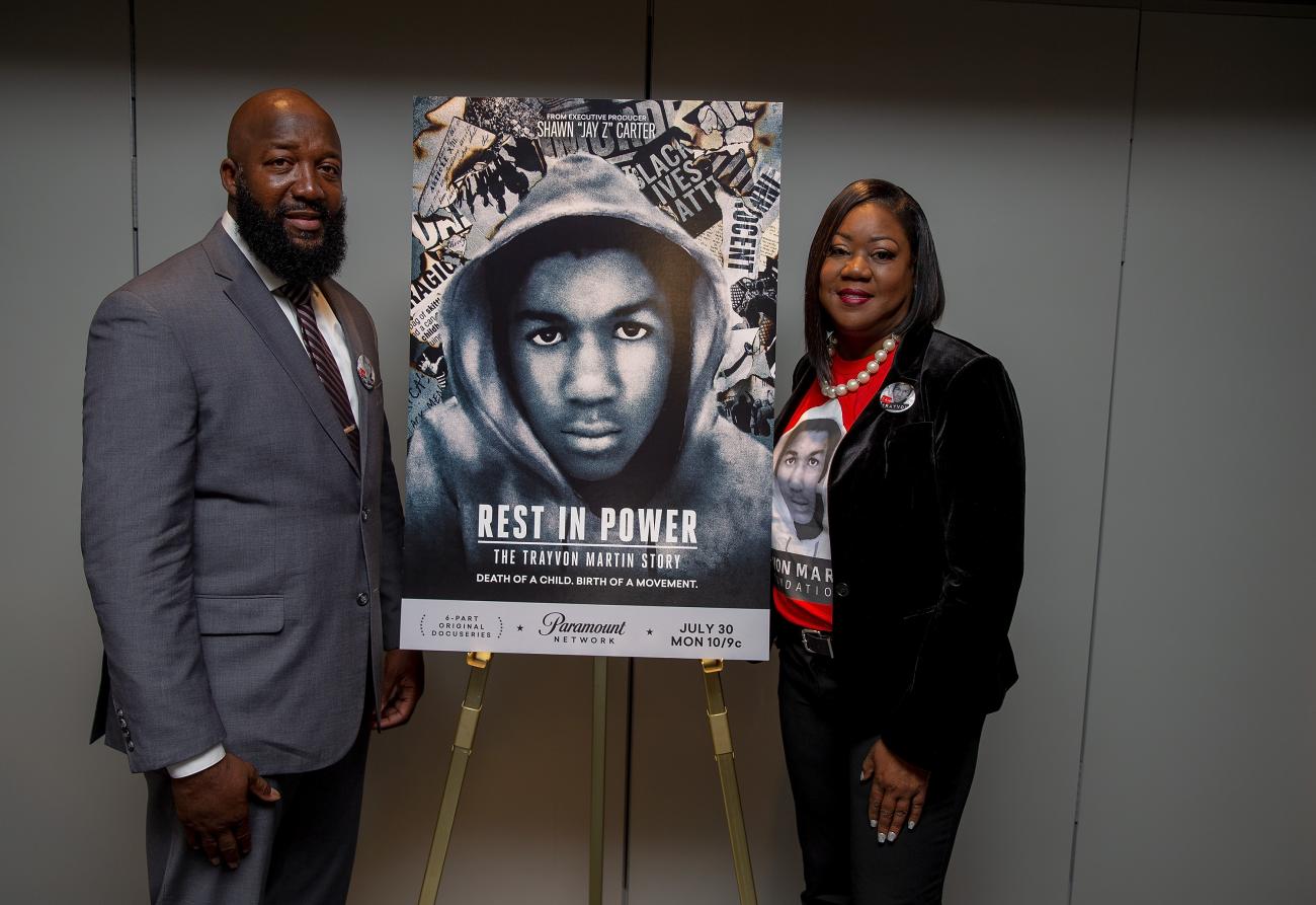 A photo of Tracy Martin and Sybrina Fulton standing next to a film poster