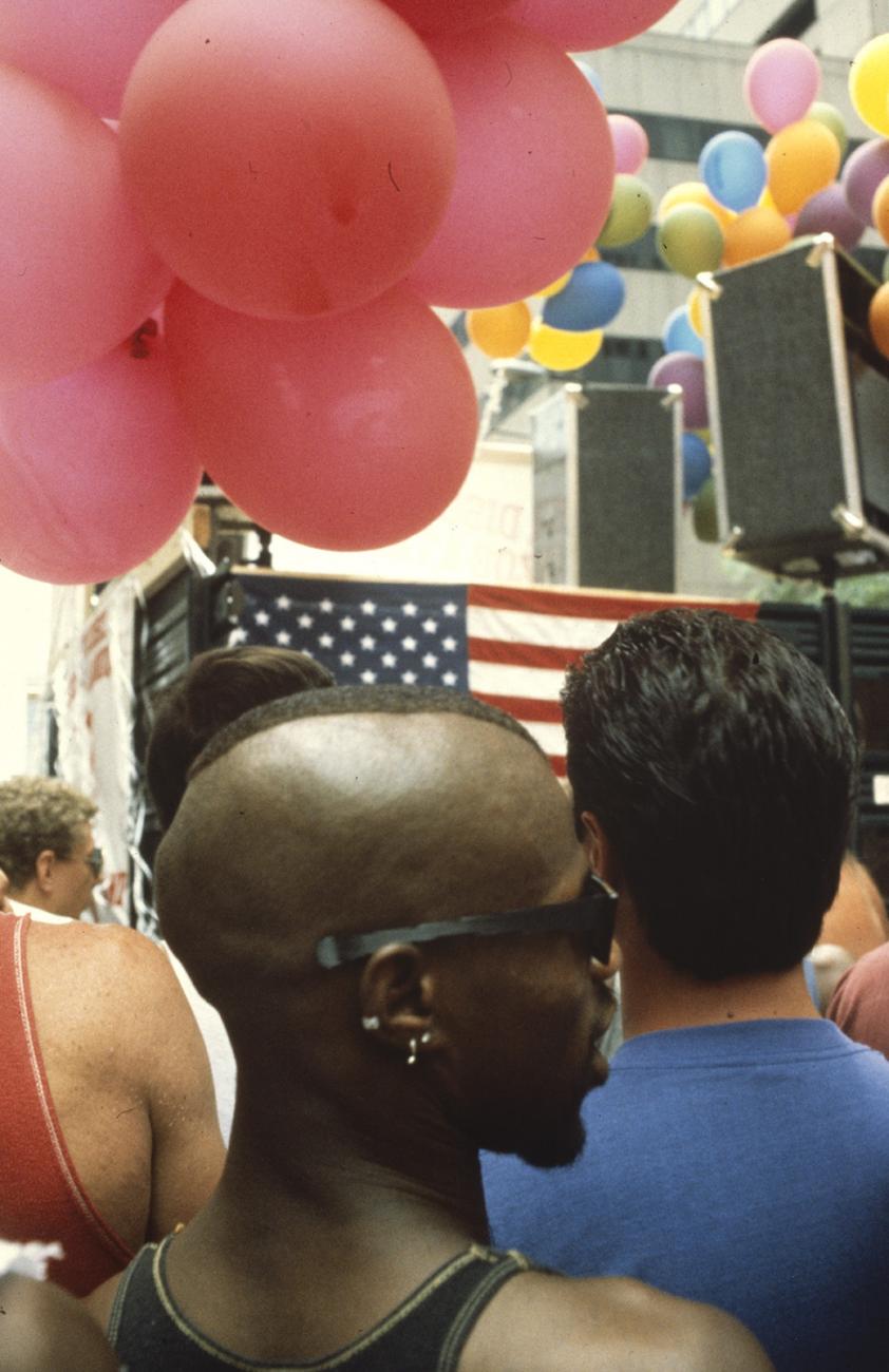 A color photographic slide depicting several individuals standing at a New York Gay Pride Parade