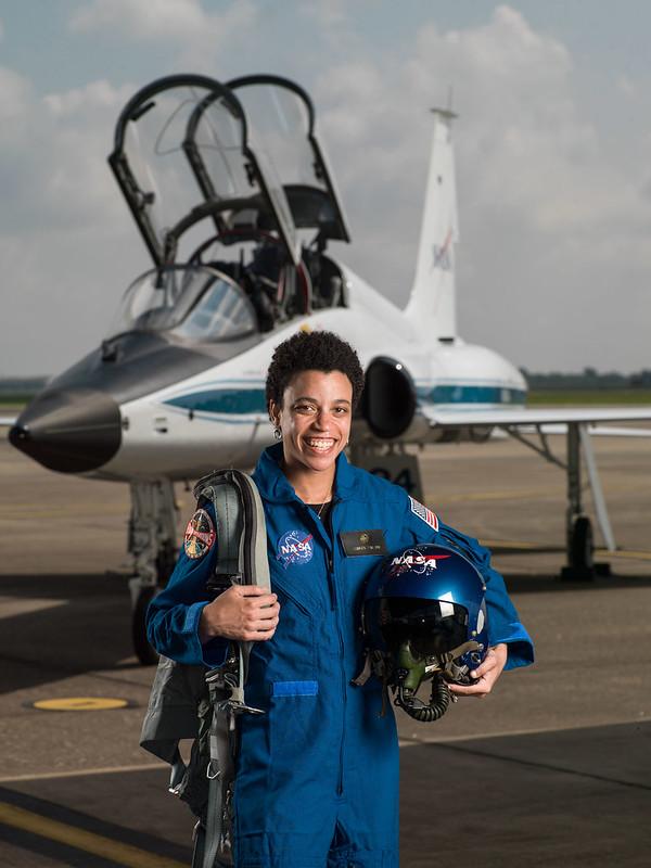 NASA astronaut Jessica Watkins standing in front of a fighter jet with the cockpit open