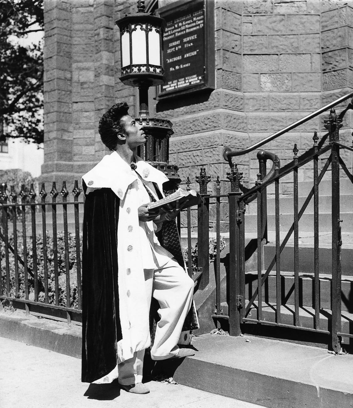 Image of Little Richard standing on a stairway stoop praying