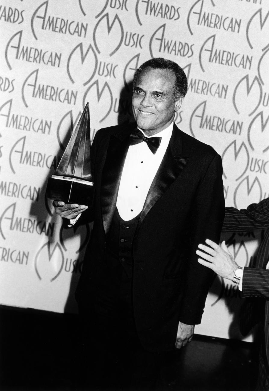Harry Belafonte holds his Appreciation Award for his work with USA For Africa at the 13th annual American Music Awards.