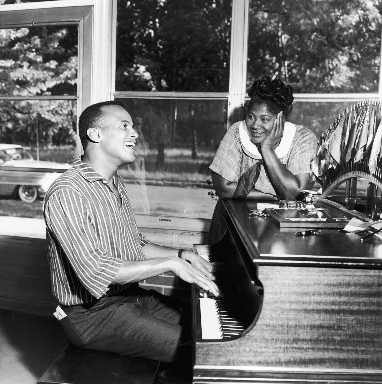 Harry Belafonte sings to Mahalia Jackson during a visit to her Chicago home.