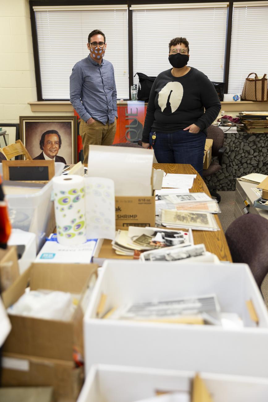 Two people standing in a room full of historical materials