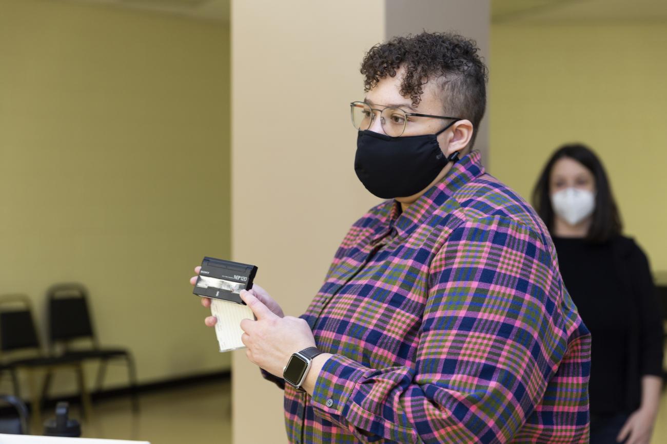 A person pointing to a cassette