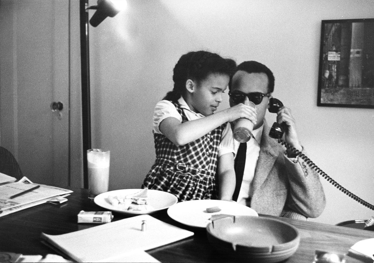 Harry Belafonte photographed sharing a father-daughter moment in his office.