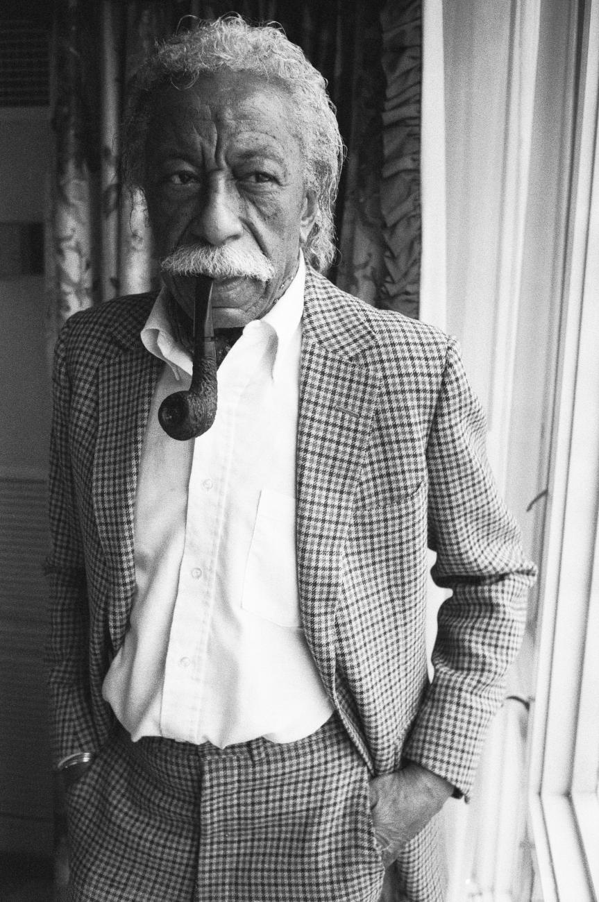 Photographer and film director Gordon Parks smoking a pipe