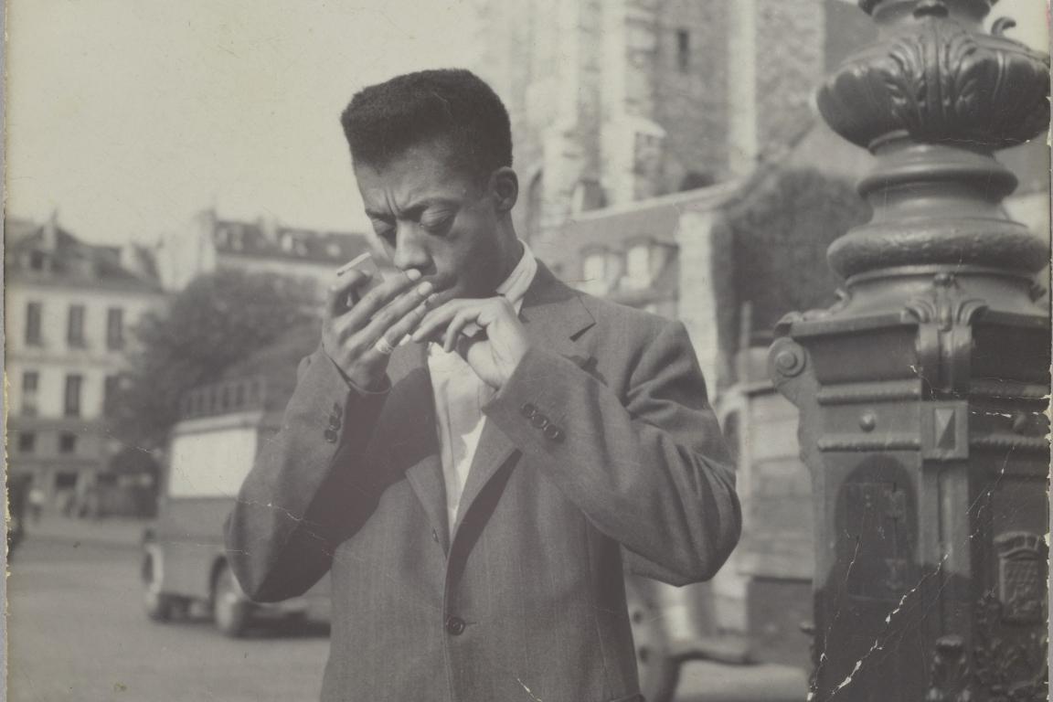 Baldwin lights a cigarette in Paris
