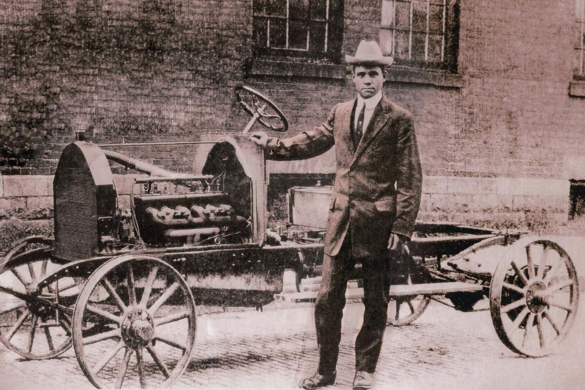 Frederick Patterson standing beside a bare Patterson-Greenfield automobile chassis.