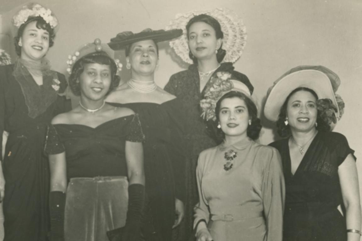 Mae Reeves with women wearing hats