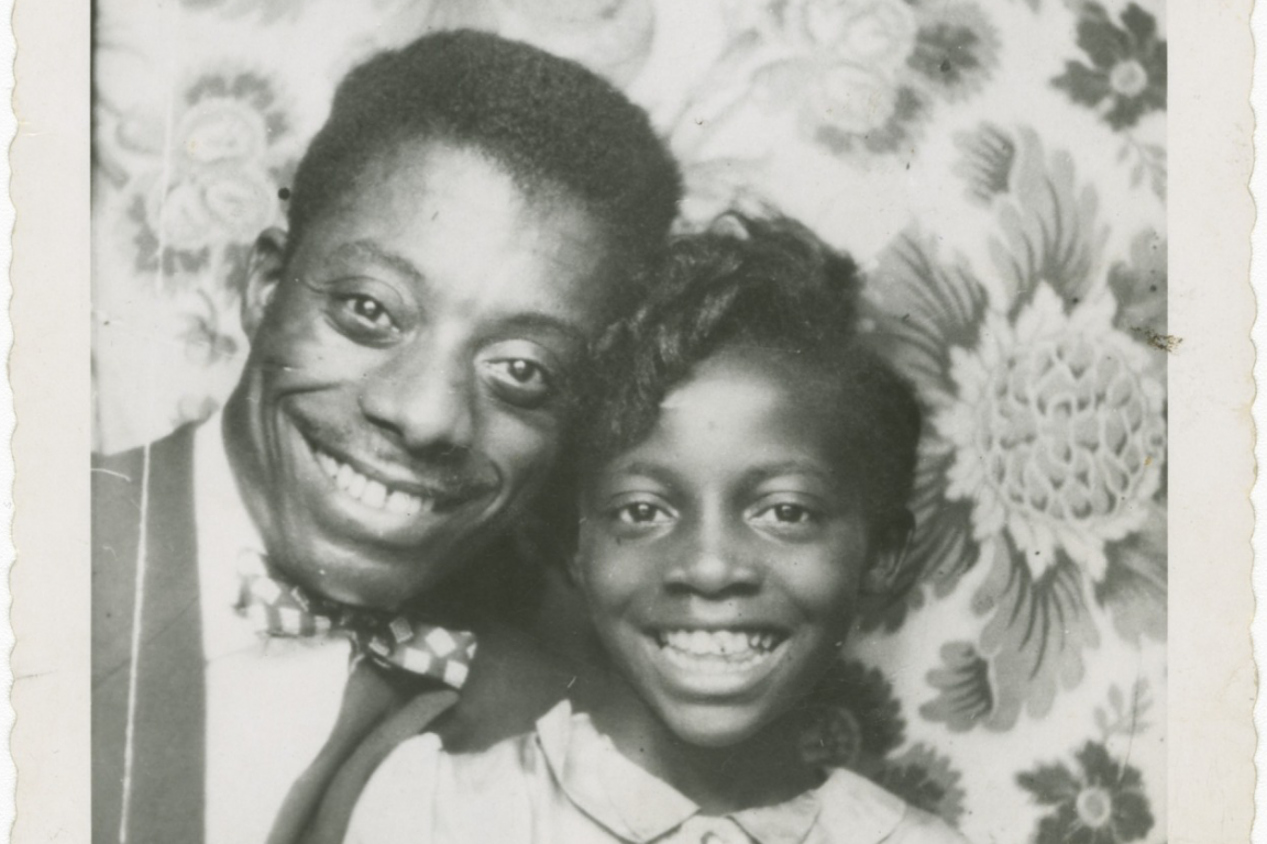 A black-and-white photograph of James Baldwin and his youngest sister, Paula.