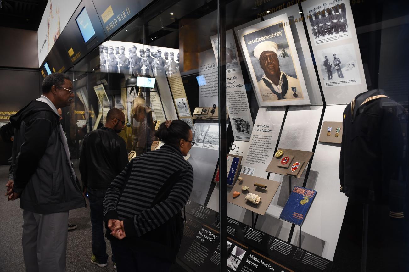 Visitors view an exhibit that highlights the legacy of Mess Attendant Doris "Dorie" Miller at the Smithsonian National Museum of African American History & Culture. Miller was awarded the Navy Cross for his extraordinary courage during the Dec. 7, 1941 Japanese attack on Pearl Harbor.