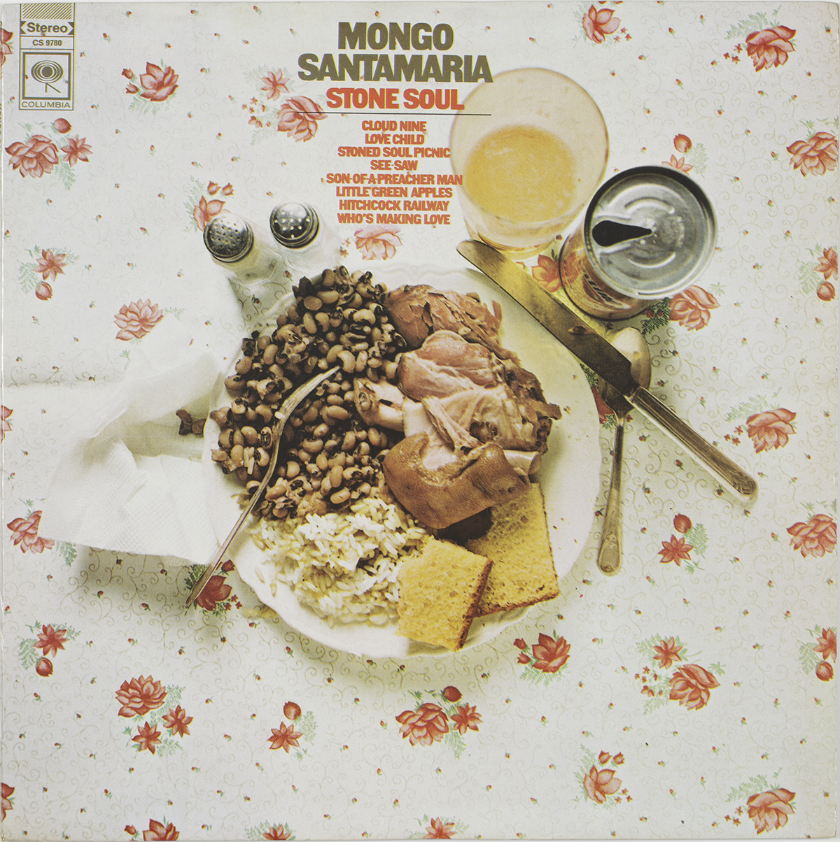 Long-playing record and album cover with sleeve. Album cover front features a color image of a place setting with food on a floral tablecloth. At the top center is brown and red text with the album name, artist, and tracks