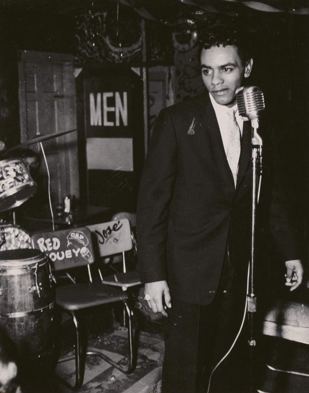 Johnny Mathis standing at a microphone.