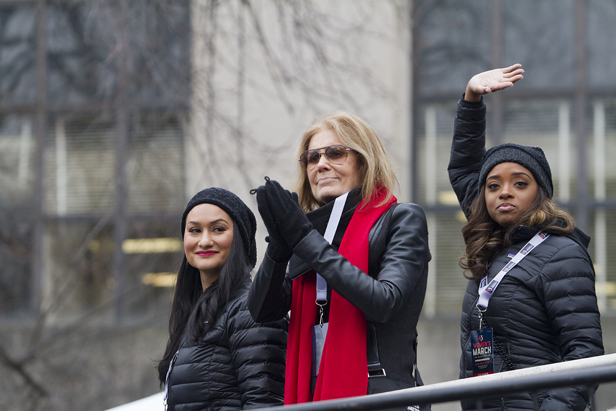 A digital image of Women's March organizers Carmen Perez and Tamika Mallory on a platform with Gloria Steinem.