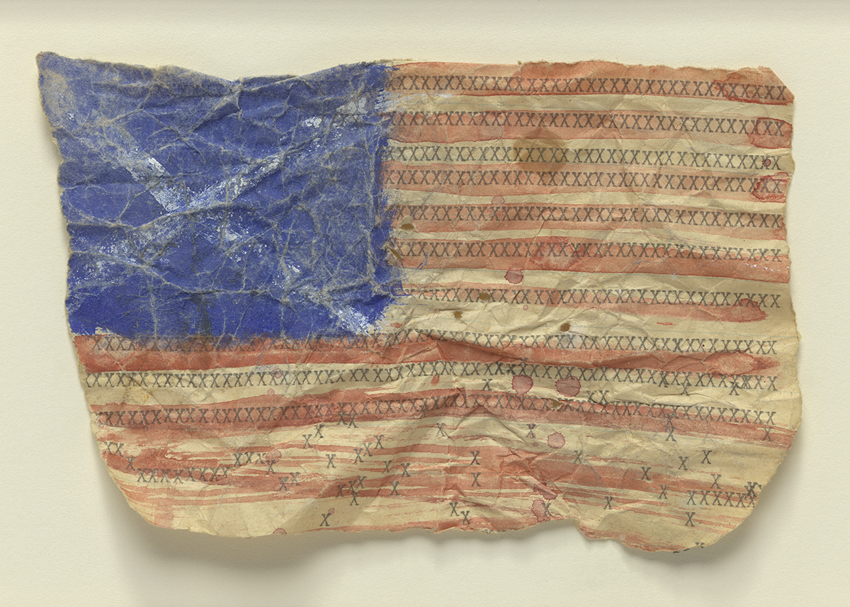 a small, painted rendition of the American flag on a crumpled piece of paper, with the flag reaching to all four edges of the paper.