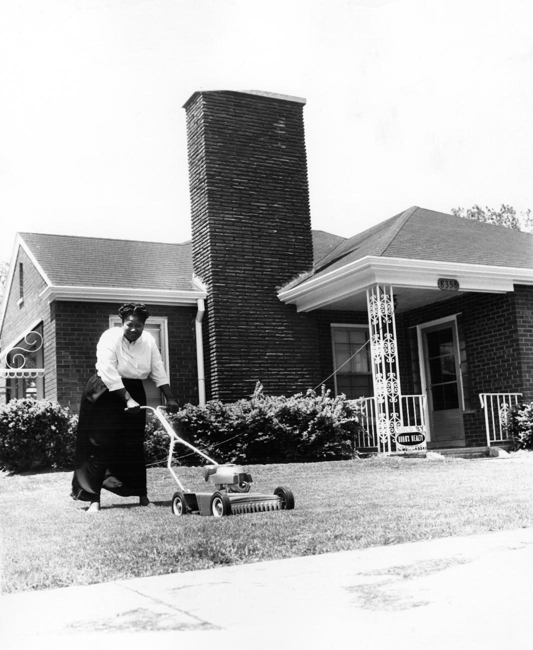 Gospel legend Mahalia Jackson mowing the lawn in front of her Chicago home at 8358 S. Indiana Avenue, Chicago, ca. 1960