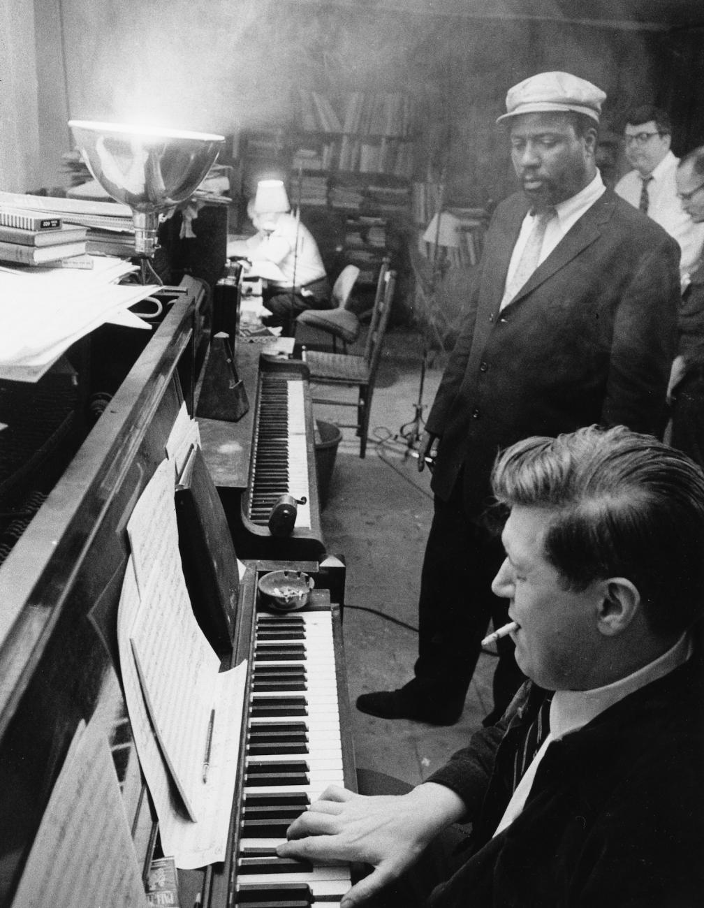 Thelonious Monk (standing) with classical composer and Julliard teacher Hall Overton (sitting) at photographer's Eugene Smith's jazz loft on 6th Avenue in New York, 1959