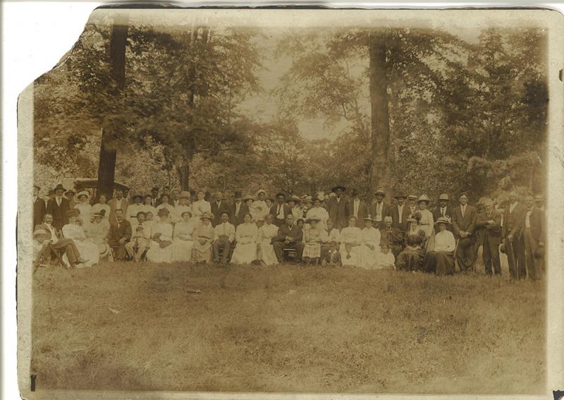 A black and white photo of a group of African Americans in the 1910s attending a family reuinion