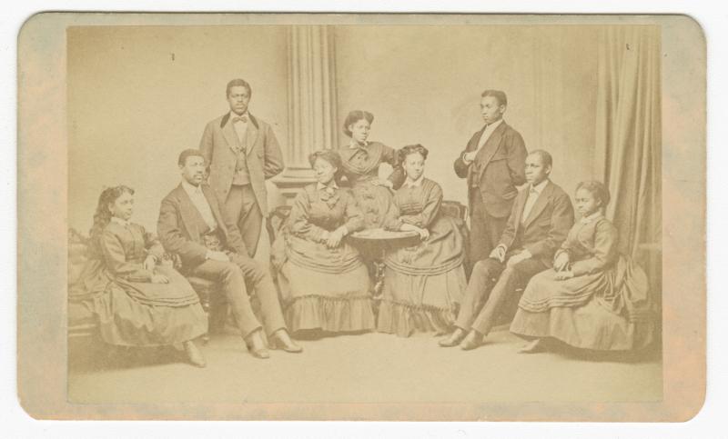 carte-de-viste depicting the Fisk University Jubilee Singers with all nine members present. On the back, the photo reads "American Missionary Association. Jubilee Singers, Fisk University, Nashville, TN."