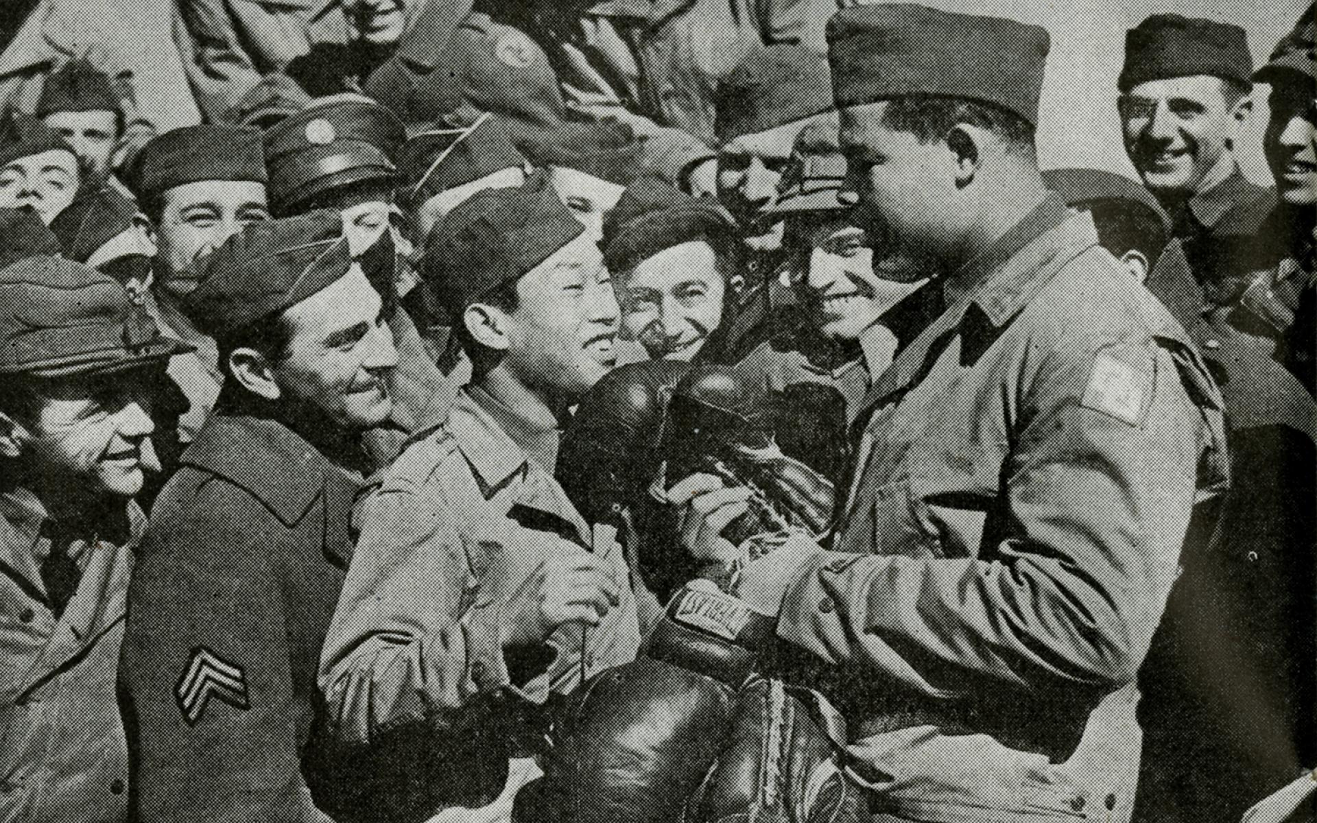 An image of a uniformed Joe Louis meeting with men in uniform.