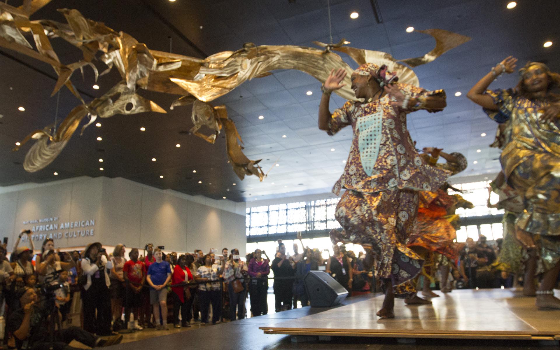 An audience watches dancers from the KanKouran West African Dance Company perform on stage