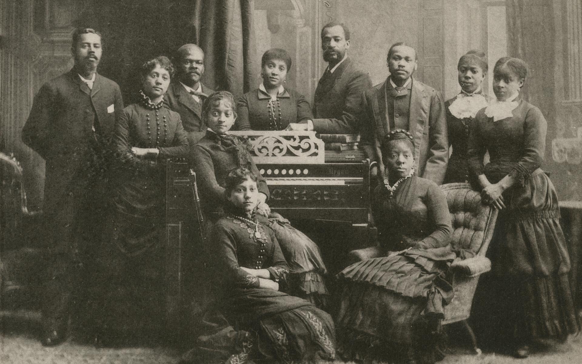 Members of the Fisk Jubilee Singers around an organ.