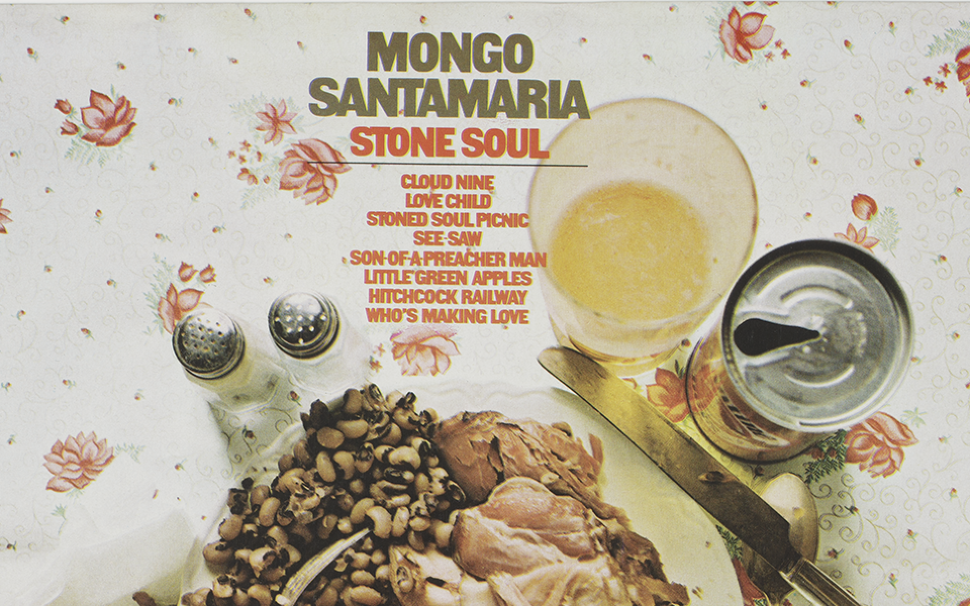 Long-playing record and album cover with sleeve. Album cover front features a color image of a place setting with food on a floral tablecloth. At the top center is brown and red text with the album name, artist, and tracks