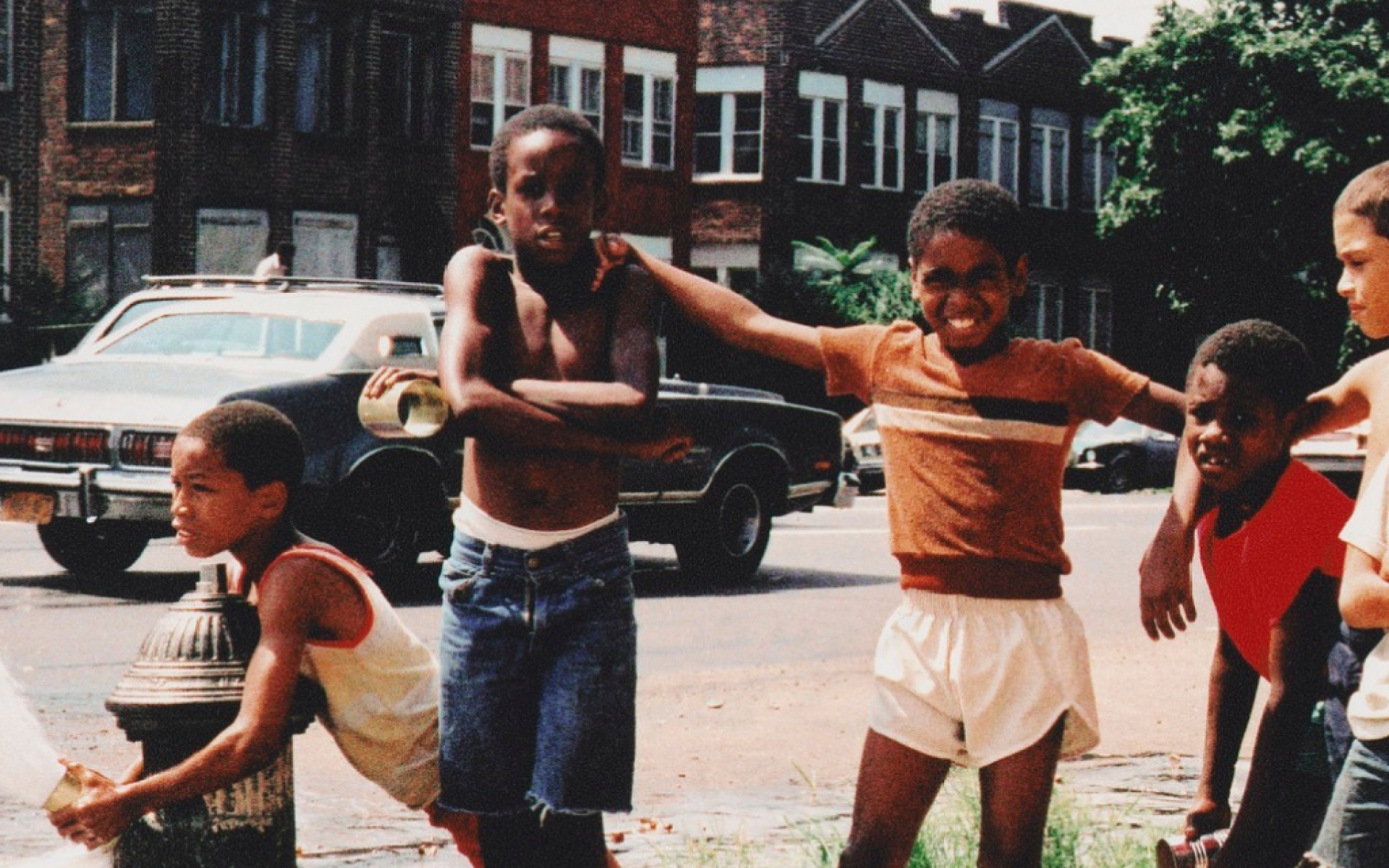 young boys opening a fire hydrant on a summer day in the Brownsville section of Brooklyn, New York, in 1980.