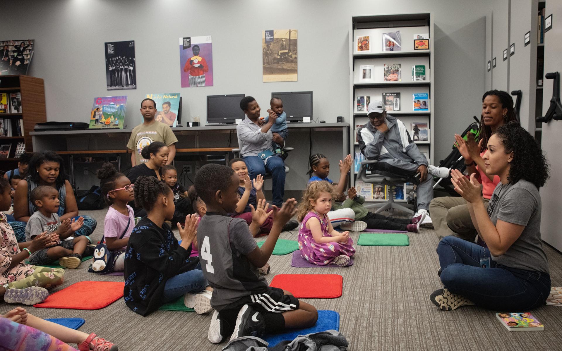 Museum early childhood education staff lead care givers and children in a program