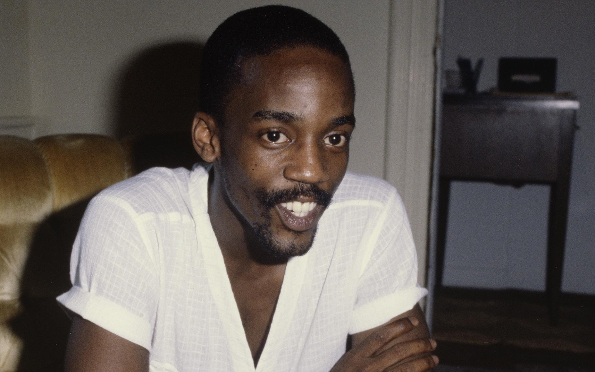 A color photographic slide featuring poet Essex Hemphill sitting in front of a chess board.
