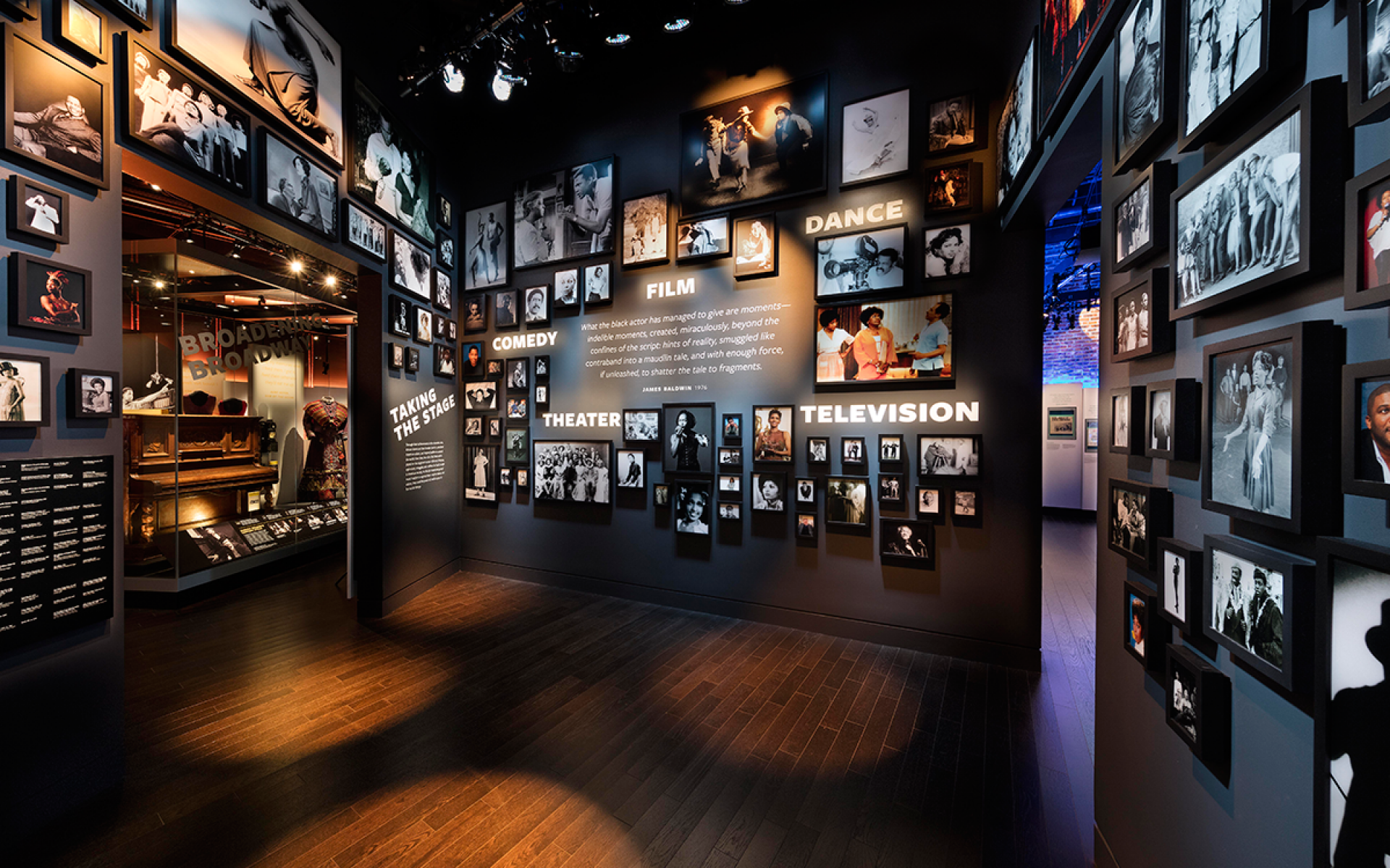 Entrance to Taking the Stage exhibition. Framed photographs of African American artists on the stage and screen are featured on the walls.